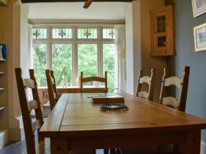 une salle à manger avec une table et des chaises en bois dans l'établissement Thorn Cottage, à Spark Bridge
