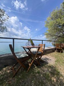 ein Tisch mit einem Vogel darauf, neben dem Meer in der Unterkunft Apartments & Rooms Neno in Tribanj-Krušćica