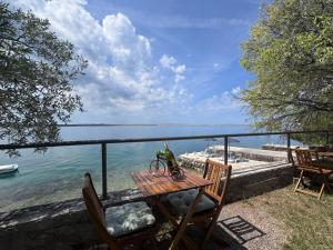 ein Picknicktisch mit einer Flasche Wein darauf neben dem Meer in der Unterkunft Apartments & Rooms Neno in Tribanj-Krušćica