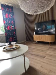 a living room with a tv and a table at Lugna Villan 4 in Köpingsvik