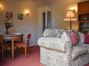 a living room with a couch and a table at New Meadows Cottage in Pickering