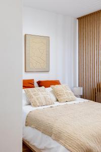 ein Schlafzimmer mit einem Bett mit weißen Laken und orangefarbenen Kissen in der Unterkunft Casa Sana - Escapade sur le Port de Sanary - Wi-Fi in Sanary-sur-Mer