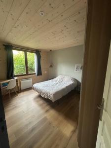 ein Schlafzimmer mit einem Bett und einer Holzdecke in der Unterkunft Appartement Confort 2 Chambres Serre Chevalier in Saint-Chaffrey