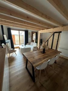ein Wohnzimmer mit einem Holztisch und einer Couch in der Unterkunft Appartement Confort 2 Chambres Serre Chevalier in Saint-Chaffrey