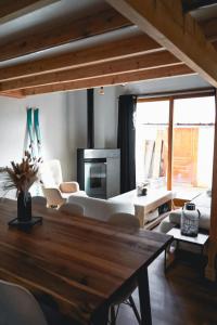 ein Wohnzimmer mit einem Tisch und weißen Möbeln in der Unterkunft Appartement Confort 2 Chambres Serre Chevalier in Saint-Chaffrey