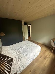 ein Schlafzimmer mit einem weißen Bett in einem Zimmer mit Holzböden in der Unterkunft Appartement Confort 2 Chambres Serre Chevalier in Saint-Chaffrey + 9 Fotos