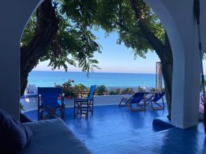 a porch with chairs and a view of the ocean at House on the beach in Skiros