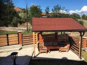 a gazebo with two chairs and a red roof at Casa Maya & Cristi in Orşova +3 photos