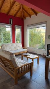 a bedroom with two beds and a table and windows at Esquel Apart Chalet in Esquel