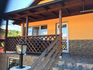 a house with a wooden deck and a lamp at Casa Maya & Cristi in Orşova
