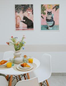 a table with plates of food and a black cat at Apartament 3A na ul Wiejskiej 32c in Oświęcim