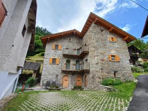 a large stone building with a balcony at Casa di Canete in Villa di Chiavenna