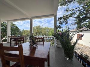 eine Veranda mit einem Holztisch und Stühlen auf einer Terrasse in der Unterkunft Apartments & Rooms Neno in Tribanj-Krušćica