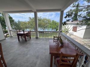 eine Veranda mit Tisch und Stühlen und Blick auf das Wasser in der Unterkunft Apartments & Rooms Neno in Tribanj-Krušćica + 34 Fotos