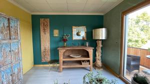 una stanza con pareti verdi e un tavolo con uno specchio di Ferienwohnung Rosen-Holz, Ruhe und Entspannung im Dorf a Niederdorla