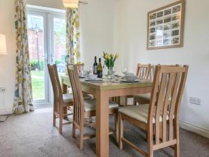 a dining room with a wooden table and chairs at Arthur's Place in Reighton