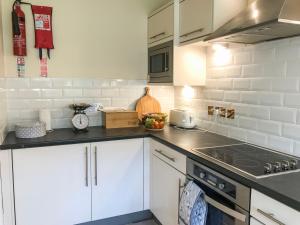 a kitchen with white cabinets and a stove top oven at Arthur's Place in Reighton