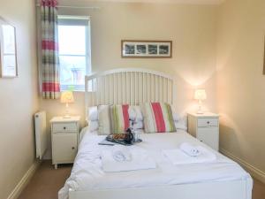 a bedroom with a white bed with towels on it at Arthur's Place in Reighton