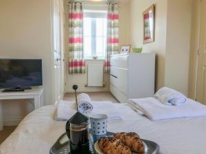 a room with a bed with a tray of food on it at Arthur's Place in Reighton +10 photos