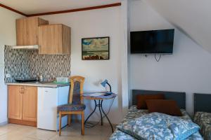 a room with a kitchen and a bed and a table at PSZCZÓŁKA in Białogóra