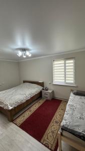 een slaapkamer met 2 bedden en een rood tapijt bij Чолпон-Ата! 700 м от берега! in Cholpon-Ata