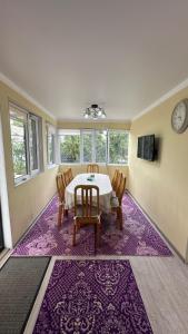een eetkamer met een tafel en stoelen op een paars tapijt bij Чолпон-Ата! 700 м от берега! in Cholpon-Ata