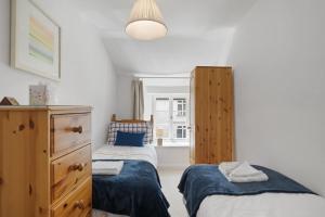 ein Schlafzimmer mit zwei Betten und einer Kommode in der Unterkunft Historic Cottage & Garden nr Quantock Hills in Nether Stowey