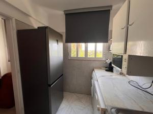 a kitchen with a black refrigerator and a counter at Green Apartment 14 in Tavira Garden in Tavira +31 photos
