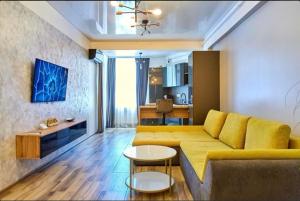 a living room with a yellow couch and a table at HF - Mamaia Nord Building Resort in Mamaia Sat/Năvodari