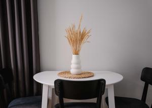 a white table with a vase on top of it at Freda Self Check-in in Nida