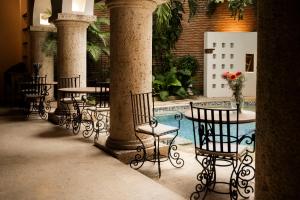 a patio with tables and chairs and a pool at Hotel Boutique Patio Corao by GEH Suites in Cartagena de Indias