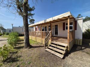 mały dom z gankiem i drzewem w obiekcie La cabane oceane w mieście Lège-Cap-Ferret