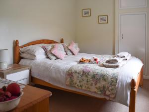 a bedroom with a bed with a tray of food on it at Cobb's Cottage in Grosmont