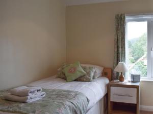 a small bedroom with a bed and a window at Cobb's Cottage in Grosmont