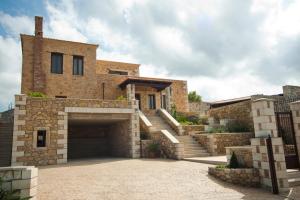 a large brick house with a garage and stairs at Villa-Aristotelis in Gerani