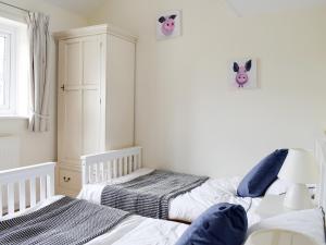 2 Einzelbetten in einem Zimmer mit weißen Wänden in der Unterkunft Rudda Farm Cottage - Uk2492 in Staintondale + 6 Fotos