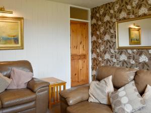 een woonkamer met twee leren banken en een tafel bij Thurston View in Coniston