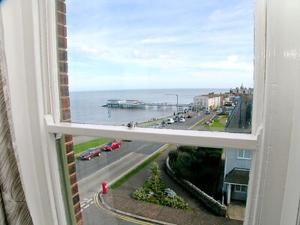 a window with a view of the ocean and a street at Sky Lark in Cromer
