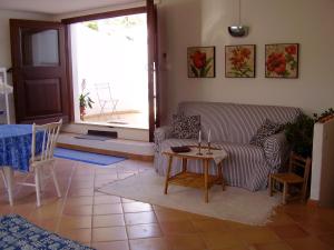 ein Wohnzimmer mit einem Sofa und einem Tisch in der Unterkunft Casa Balente in Àrbatax
