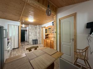 a kitchen and dining room with a wooden table in a room at Faház - Nyaraló a Tiszánál in Tiszacsege