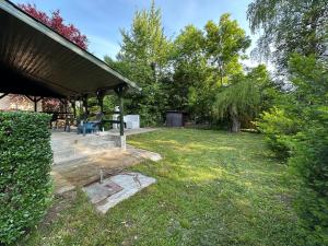 a yard with a pavilion with a table and chairs at Faház - Nyaraló a Tiszánál in Tiszacsege