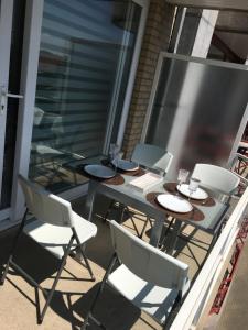 a table and chairs on a balcony with a table and glasses at Aan zee in Nieuwpoort in Nieuwpoort