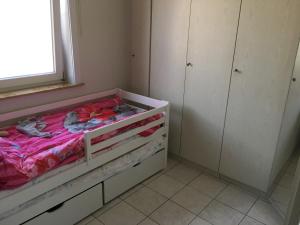 a small bedroom with a bed with pink sheets at Aan zee in Nieuwpoort in Nieuwpoort