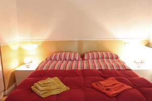 チヴィタノーヴァ・マルケにあるPino Marittimoのベッドルーム1室(赤いシーツとランプ2つ付)