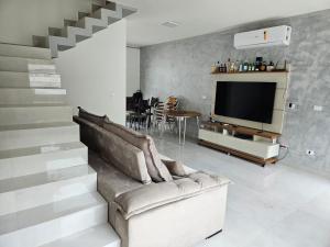 Μια τηλεόραση ή/και κέντρο ψυχαγωγίας στο Casa em Boiçucanga com 2 suítes, piscina e sauna integrada