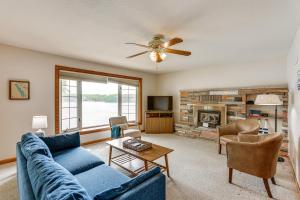 a living room with a blue couch and a fireplace at Dock and Views Scenic Lakefront Escape in Harrison in Harrison