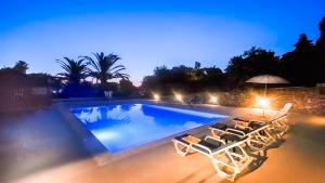 a swimming pool with lounge chairs and an umbrella at Villa Belinha B by Check-in Portugal in Quarteira