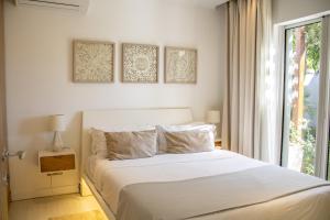 a bedroom with a white bed and a window at Comfortable villa with private pool in Grand-Baie +17 photos