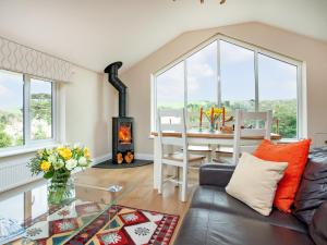 a living room with a couch and a table with a fireplace at Meadowside in Saint Mawes