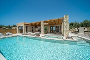 a swimming pool in front of a house at Lithos Art Villas - Utopia in Lakíthra